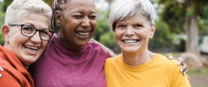 Three older women smile together