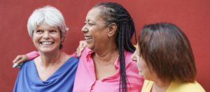 Three older women smile together