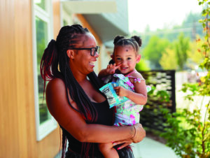 Portrait of a Cascadia resident holding her daughter.